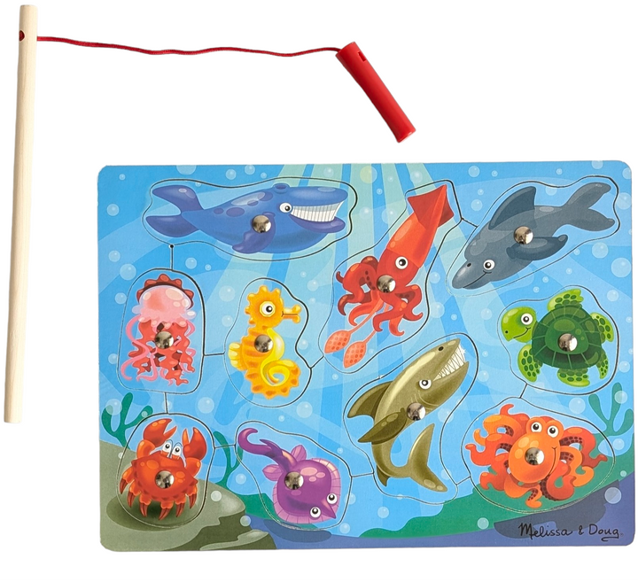 Melissa & Doug, Wooden Fishing Magnetic Puzzle Game, Cognitive & Motor Skills Development , Featuring artwork of aquatic animals, this magnetic wooden puzzle game is the perfect catch-and-release fishing program. Enjoy the task of returning the ten vibrant sea friends to the depths after using the magnetic fishing rod to "catch" them from the game board! An inventive approach to promote fine motor abilities and hand-eye coordination.